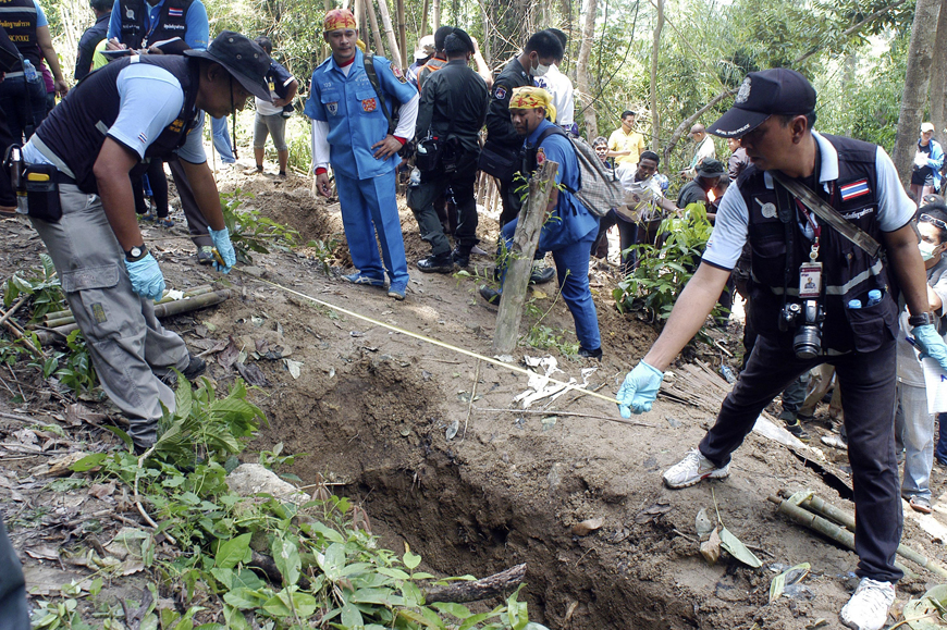 Thai police officials measure a shallow grave in Padang Besar, Songkhla province, southern Thailand, May 2 (AP photo)